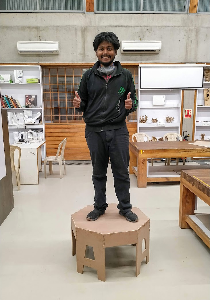 Samiul standing on a CNC-cut stool he built at a fab lab